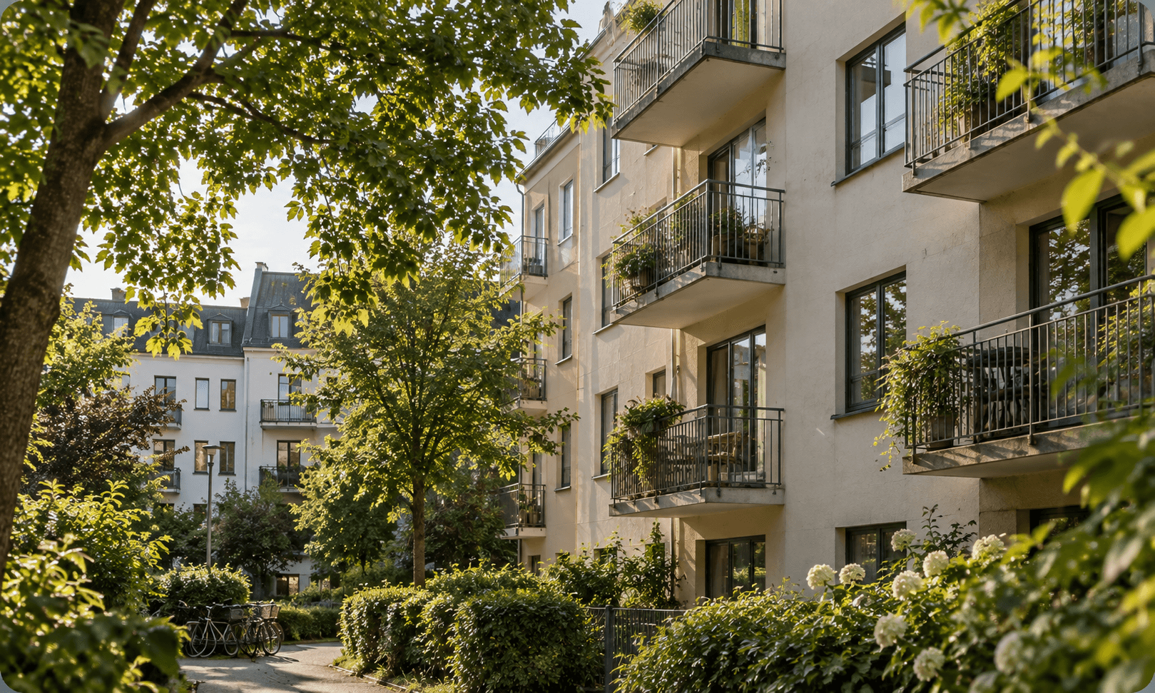 Bostadshus med balkonger och en grönskande innergård.
